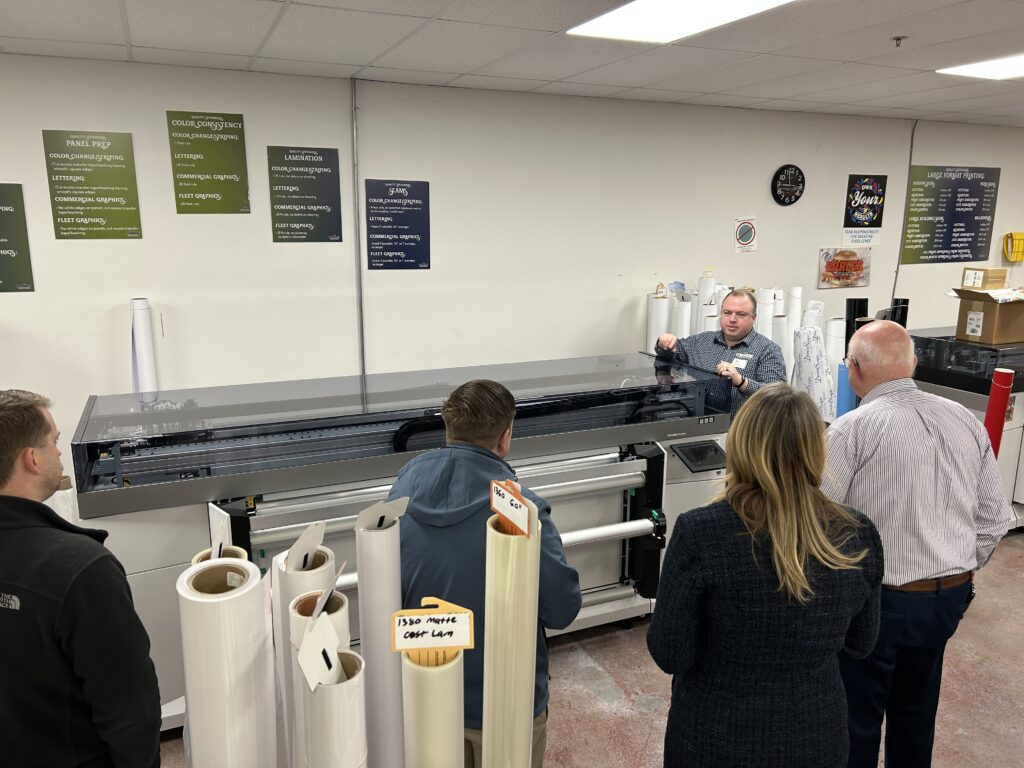 Group tour of Streamline Graphics production floor with process reference posters